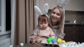 Mother and daughter paint Easter eggs. Happy family is preparing for Easter. make a video call and communicate via video communication.