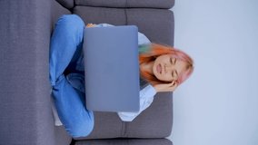 Girl with dyed hair talking on video call. Emotional and gesturing young woman with colored hair calling her friends with computer web camera. Stock video of individual female with rainbow hairstyle