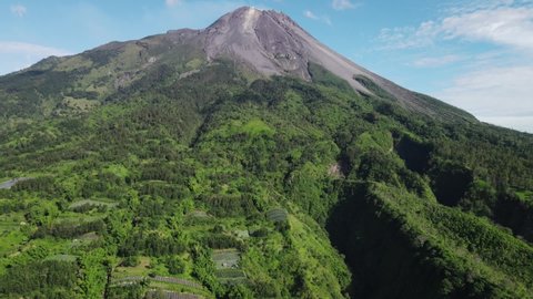The splendor of Mount Merapi surrounded by tropical forests in Java, Indonesia, aerial view