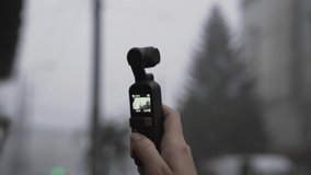 One woman recording video of building with small device, selective focus, close up