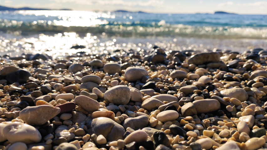 Sea Waves On Beach Pebbles is a stock video that contains beautiful close-up footage of a sea waves washing up beach pebbles. | Shutterstock HD Video #1084485523
