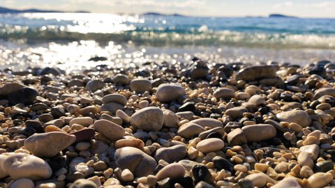 Sea Waves On Beach Pebbles is a stock video that contains beautiful close-up footage of a sea waves washing up beach pebbles.