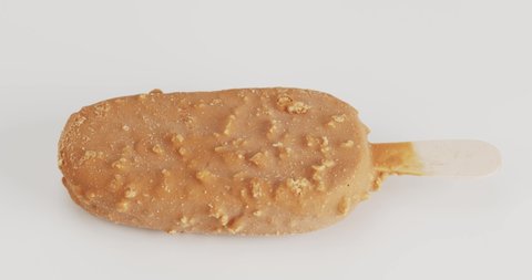 Front view, Melting of ice cream flavored vanilla on the sticks. The texture of the ice cream after melting flows from the sticks. On the white background.