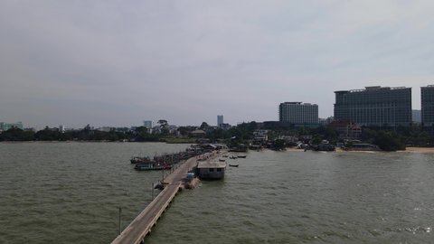 Aerial footage of the Pattaya Fishing Dock fishing showing boats moored and the city of Pattaya, Chonburi, Thailand