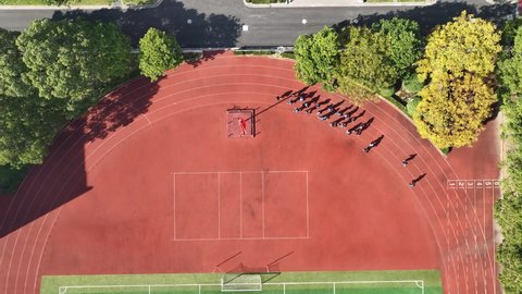 Drone aerial view of people running at the football stadium Shanghai China. Group of people on the running track, the football field or soccer field. Sports, school and health concept b-roll footage