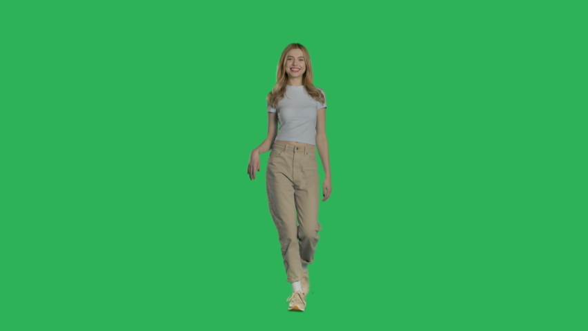 Casual young blonde woman walking. Girl makes sign by fingers. Shot on a mock-up green screen in the background. 4k uhd video on Chroma key