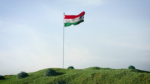 Hungary Hungarian flag waving in the wind on a beautiful landscape. Blue sky. 4K HD. Stunning image.