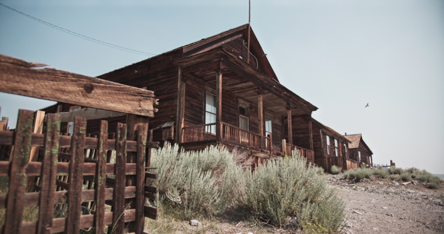 Creepy old abandoned building with birds flying all around in a western ghost town in the gold rush mining area of California