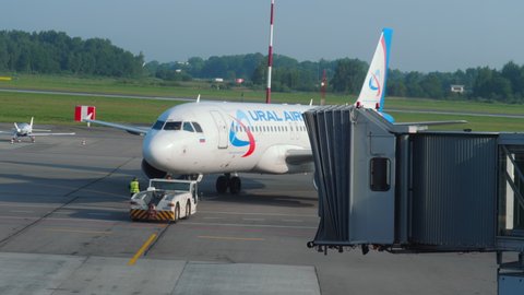 KALININGRAD, RUSSIA - JULY 28, 2021: Airplane Airbus A321 Ural Airlines runway towing at Khraborovo Airport, Kaliningrad (KGD). Passenger boarding is over. Departing flight on a summer day