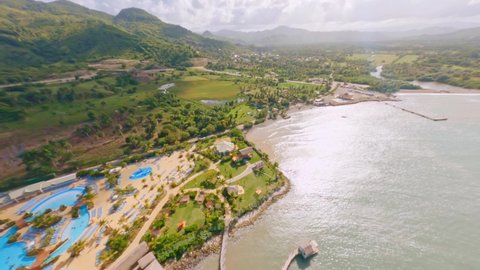 Fpv flight over Amber Cove cruise terminal in the Puerto Plata Province of the Dominican Republic. Beautiful coastline with swimming pools,retail outlets and idyllic mountain landscape in background 