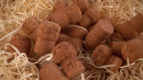 Champagne wine corks fall on the straw. Slow motion.