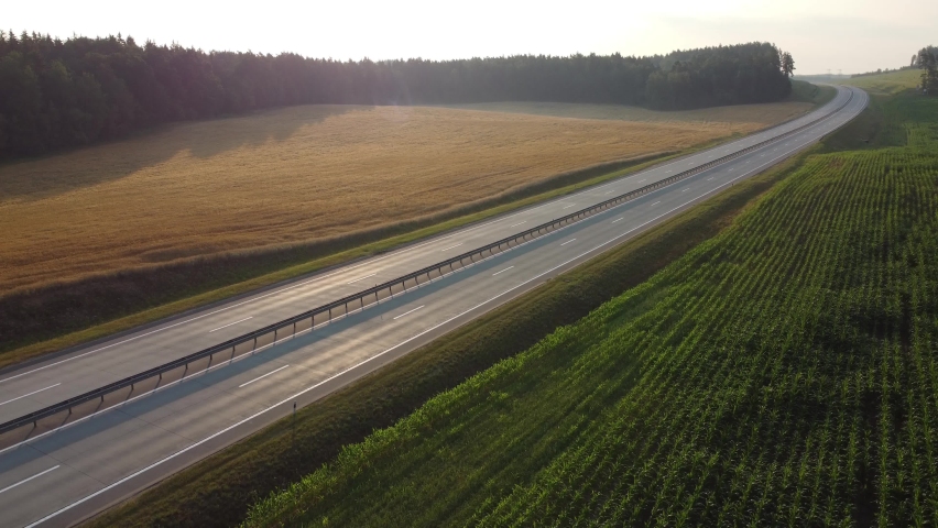 Heavy truck is carrying cargo on the highway in a beautiful area at dawn. Lorry rides through the countryside with beautiful landscape at background. International Trade, Cargo Delivery, Cargo	
 Royalty-Free Stock Footage #1084518106