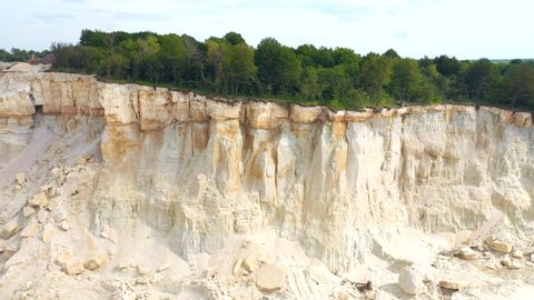 Panoramic view from the drone on the steep cliffs of the basalt quarry. Mining and production of useful minerals concept. Mining industry. Cinematic aerial shot. Beauty of world. Filmed in 4k video.