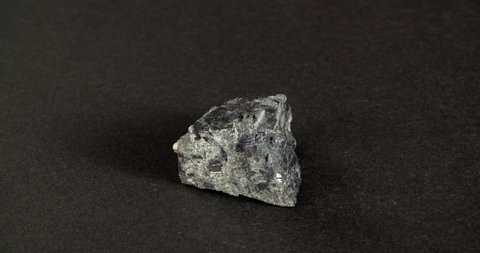 Rotation galena mineral on a black background. Lead ore.