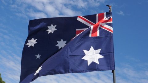 Australian Flag Waving in the Wind in Slow Motion Close Up with blue sky background. High quality 4k footage