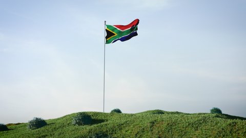 South Africa, South African flag waving in the wind on a beautiful landscape. Blue sky. 4K HD. Stunning image.