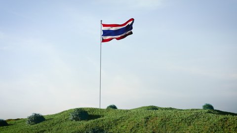 Thai, Thailand flag waving in the wind on a beautiful landscape. Blue sky. 4K HD. Stunning image.