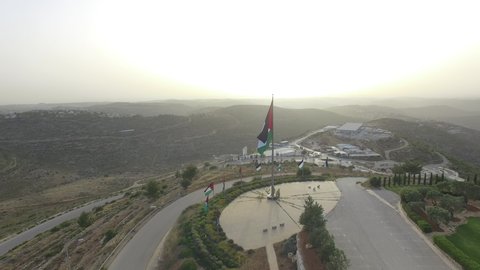 aerial shot of a Palestinian flag on A hillside, above the city, Palestine