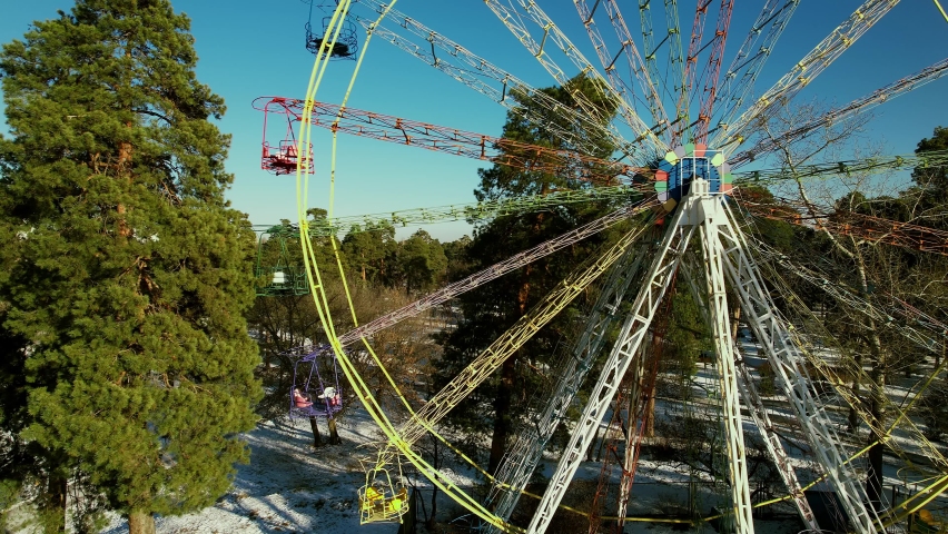 Abandoned attraction Ferris wheel in the winter city park. Aerial
