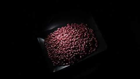 Red beans in a black tray turning