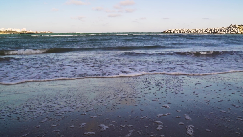 Steady shot of Black Sea's waves in Constanta beach in Fall, cold and sunshine contrast