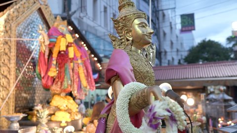 Gold statue of a deity Phra Visachanu In Ganesh shrine. People come to worship for success at Phra Pikanet temple. Huai Khwang, Bangkok, Thailand. 4k, 10bit, 422, 50fps.