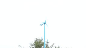 Wind turbine planted countryside for generating electricity as alternative power resource. The wind makes the blade of the turbine keep spinning. 