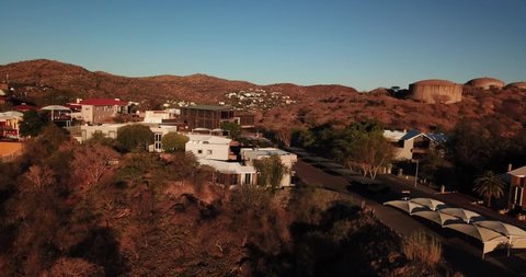 Windhoek, Khomas Region, central Namibia, 09.01.20: 4K aerial Windhoek capital residential central hilly district bright sunset drone video, upmarket houses, old white walls German mansion on hill top