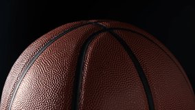 Close up shot of rotating basketball ball on dark black background. Basketball concept. - Powered by Shutterstock - Get 15% off with code: PIKWIZARD15
