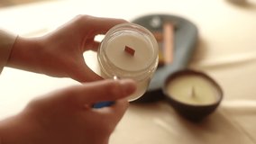 Close-up cropped shot of unrecognizable young woman lighting handmade aroma candle holding in hand. Closeup of female burn up with lighter aroma relaxing candle at home. Shooting in slow motion. - Powered by Shutterstock - Get 15% off with code: PIKWIZARD15
