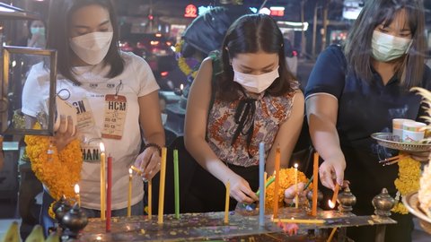 Asian young women praying, put candles to Ganesh God for love, luck and success. Ganesh temple Shrine, Huai Khwang, Close up, 4k, 10bit, 422, 50fps. Bangkok, Thailand 15 Nov 2021