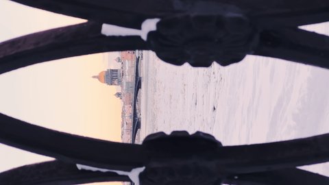 Russia, St. Petersburg, 07 December 2021: Slow motion footage of winter view of St. Petersburg at sunset, steam over frozen Neva river, huge ship moored near Blagoveshenskiy bridge