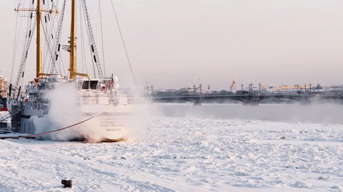 Russia, St. Petersburg, 07 December 2021: Slow motion footage of winter view of St. Petersburg at snow storm, frozen Neva river, huge ship, Isaac cathedral, car traffic on Blagoveshenskiy bridge