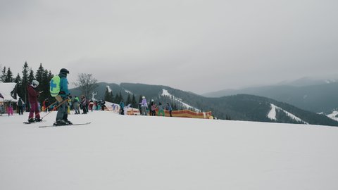Bukovel, Ukraine, december 2021: Skiers going downhill in a ski resort, active rest in winter mountains
