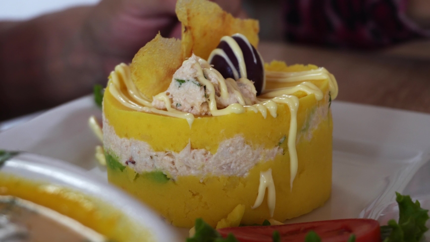 close-up of a plate stuffed with fish with olives, mayonnaise, fried banana and tomato and lettuce in a marine restaurant in the daytime in 4K