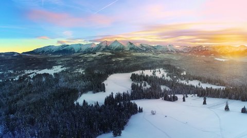 Snow capped mountains in the winter and colorful sunset sky, aerial view. Tatra high mountains and magical unspoiled scenery.