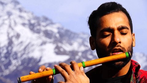Close video of a man playing flute