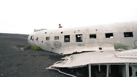 VIK, ICELAND - AUGUST 3, 2019: Tourists walk along plane wreck exterior on Solheimasandur Beach
