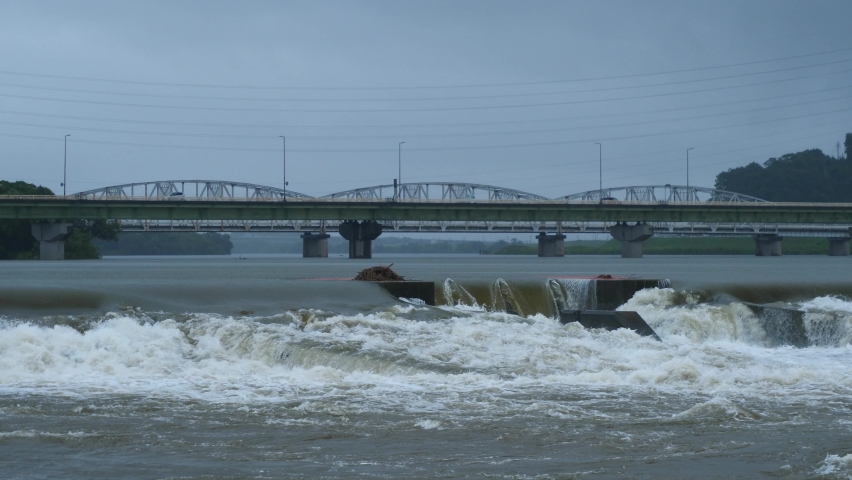 A river flooded by heavy rain. A car crossing the bridge. Royalty-Free Stock Footage #1084571440