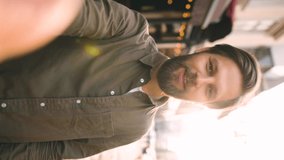 Vertical orientation of portrait of cheerful young man looking at camera and talking recording vlog. POV of handsome young bearded man making online video call looking at camera. - Powered by Shutterstock - Get 15% off with code: PIKWIZARD15