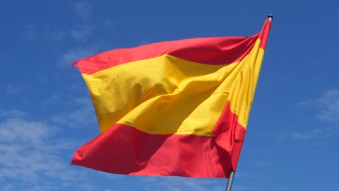 Spanish Flag Waving in the Wind in Slow Motion Close Up with blue sky background. High quality 4k footage