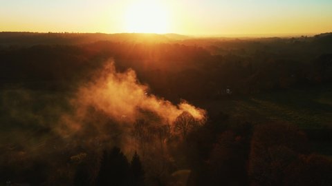 Aerial drone from an helicopter of a fire on a forest. Coal sets on fire in a farm in the woods