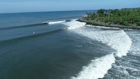 Aerial view of panga going out to the sea. Clips of surf trip in Playa Las Flores, El Salvador, a perfect right hand point break, slow motion.