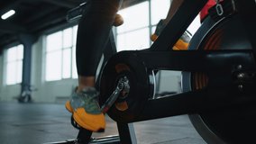Close-up woman leg spinning cycling exercising pedal on stationary machine bike at gym. Modern sport recreational activity, workout, healthy lifestyle concept. Athletic girl spinning bike. Slow motion - Powered by Shutterstock - Get 15% off with code: PIKWIZARD15