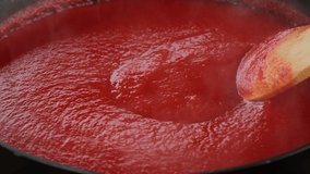 Stir tomato sauce. Cooking ketchup or tomato sauce or tomato soup in pan. 4K UHD video
