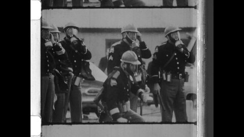 1965 Selma, AL. John Lewis leads a Civil Rights March over the Edmund Pettus Bridge. Alabama State Troopers in gas mask attack protesters with billy clubs and nightsticks. 4K Overscan of Vintage Film