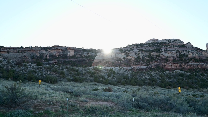 Sun setting behind red rock mountains in the Colorado National Monument, time lapse