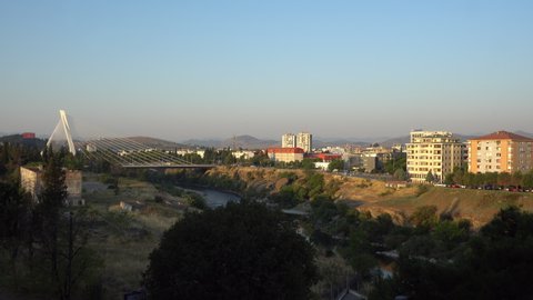 PODGORICA, MONTENEGRO - SEPTEMBER 15, 2021: Sun hits the buildings and Millennium Bridge in the morning in Podgorica, Montenegro. Editorial, 4K. Medium shot, Contains binaural audio