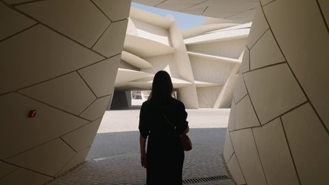 Doha, Qatar- november 2021: Woman tourist walking in National museum of Qatar interior showing the unique architecture of the museum
