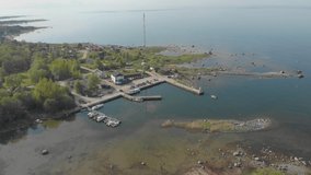 Small local harbor for ferries. Drone video of the Prangli Island public harbor. Birds eye view of Estonian small island. Port for sailing, fishing and transport ships. Sunny summer day